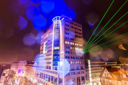 Hochhaus B59 in Jena, bei Nacht, mit grünen Lasern und blauen Flecken durch Regentropfen