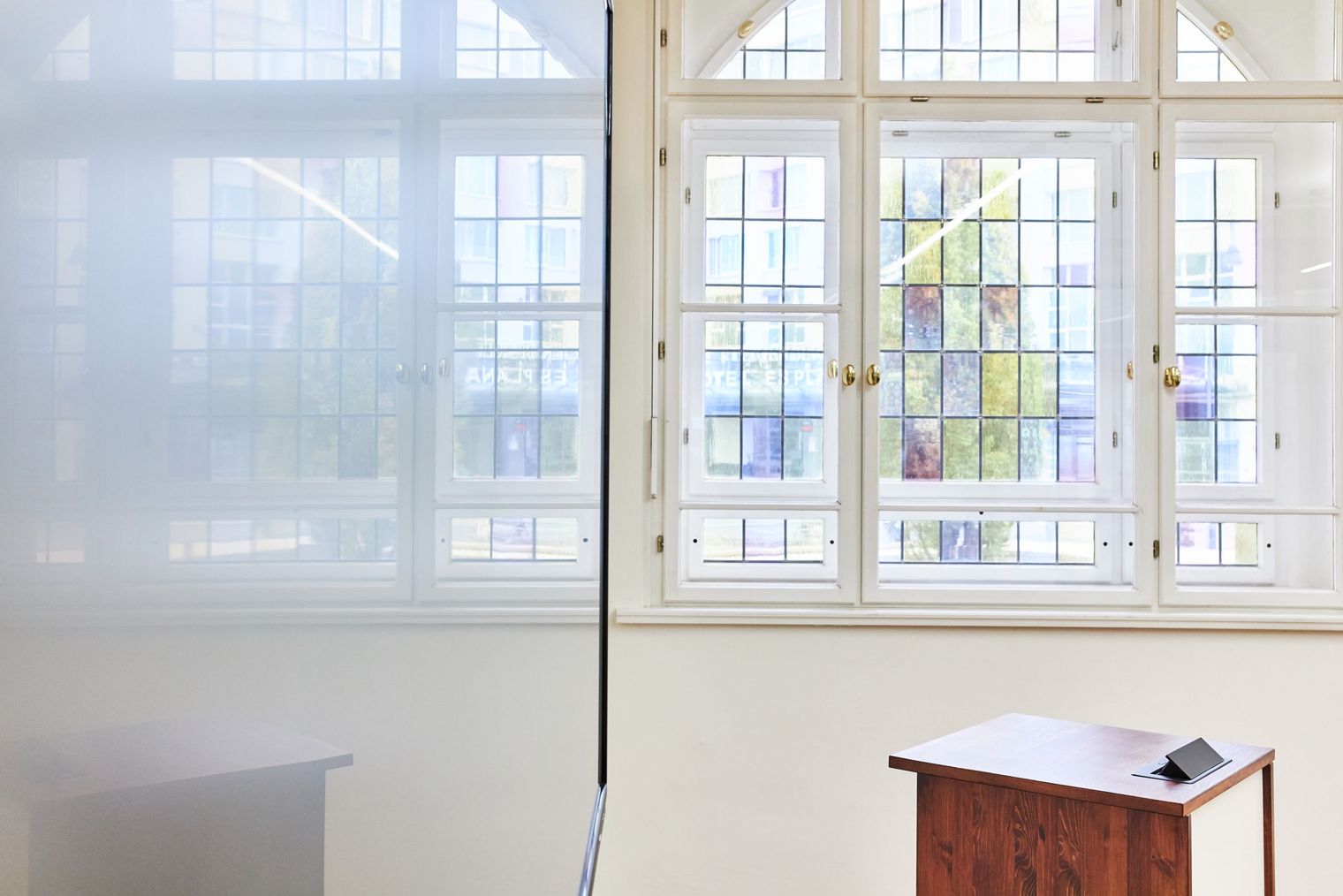 Seminarraum im Volkshaus Jena mit Buntglasfenster, durch das die Sonne scheint