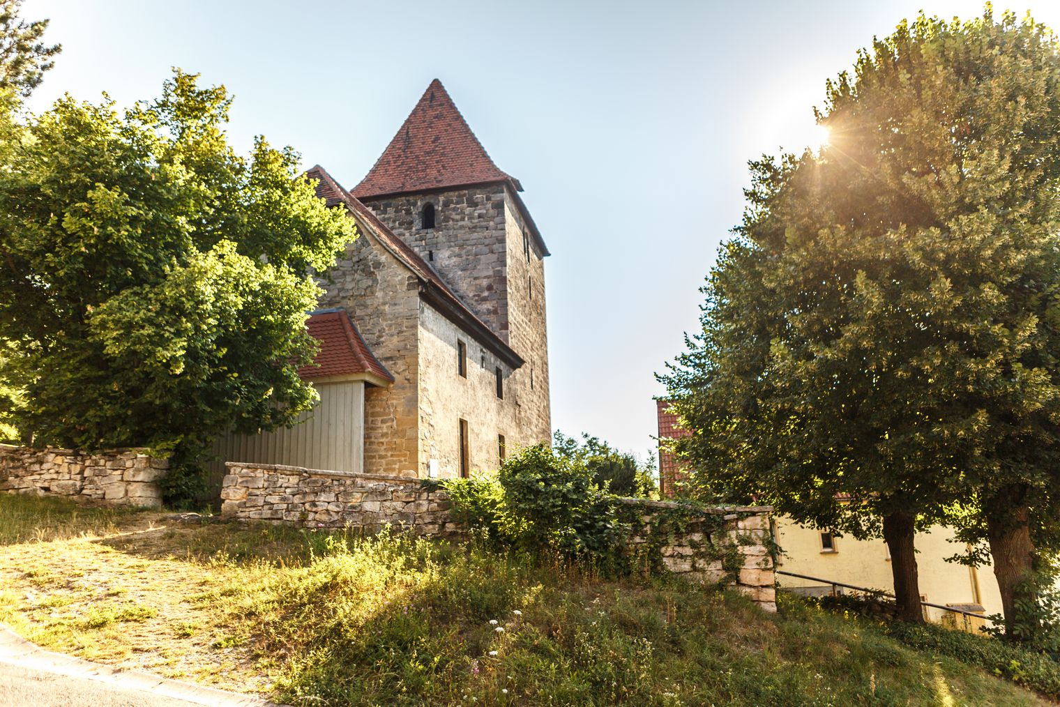 Leutra-Kirche im Grünen mit Sonneneinstrahlung